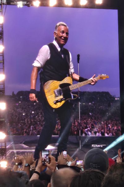 Bruce Springsteen z gitarą w ręku na tle publiczności