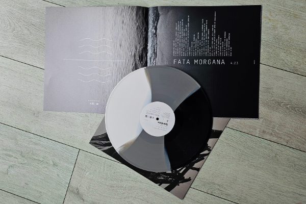 Zdjęcie wnętrza okładki płyty zespołu Spiritbox pt. "Tsunami Sea" otwartej na tekście piosenki "Fata Morgana". Tło to czarno-białe zdjęcie plaży. Na lewej stronie okładki znajduje się część zdjęcia z morzem i piktogram przedstawiający morskie fale. Na prawej stronie okładki znajduje się część zdjęcia przedstawiająca piasek i tekst piosenki. Na zdjęciu znajduje się także płyta winylowa w kolorze czarnym, szarym i białym.